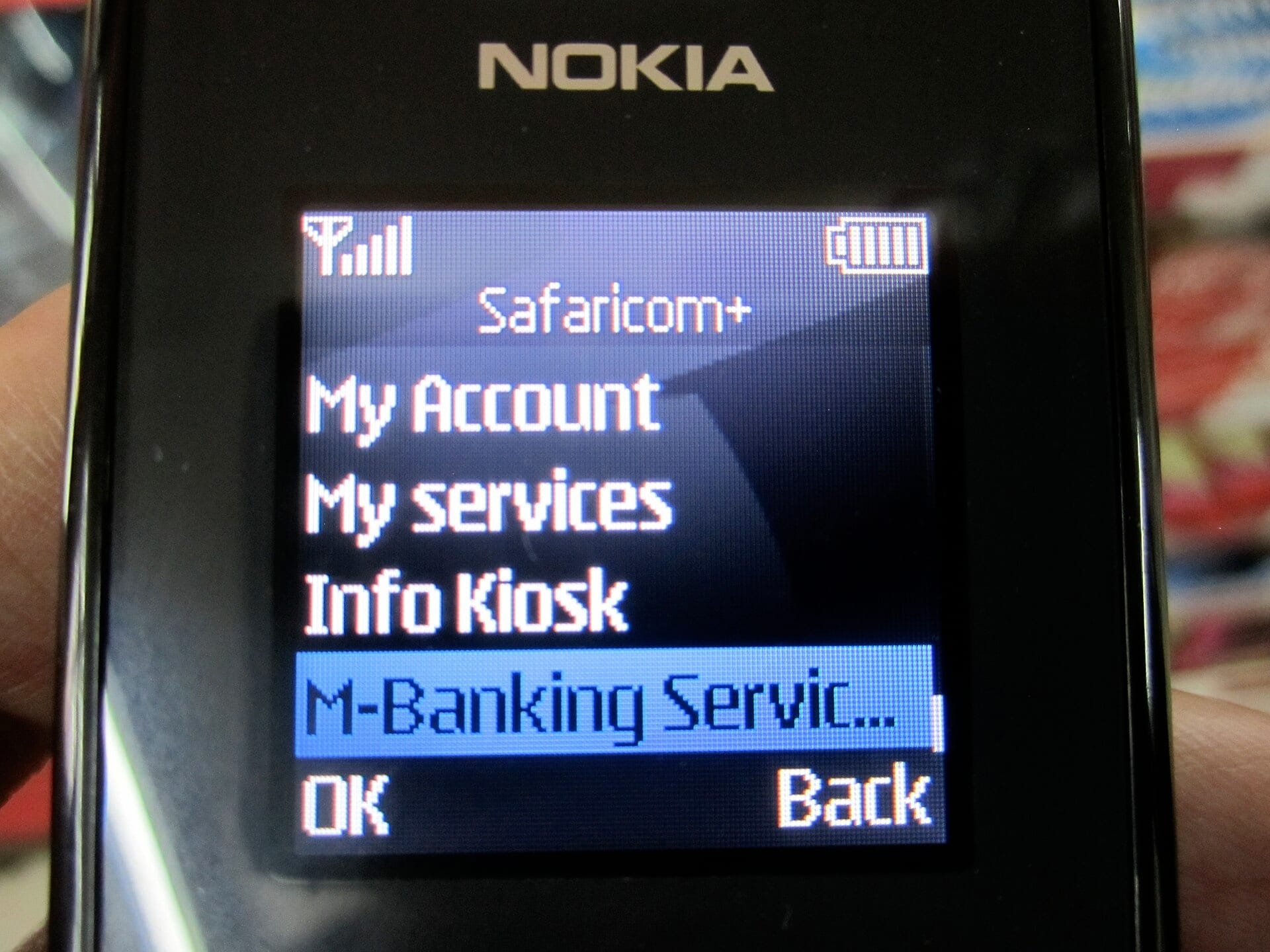 A feature phone displaying a mobile banking menu